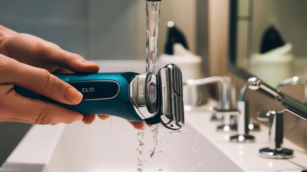 Clio shaver maintenance setup showing cleaning brush, water, and shaver head